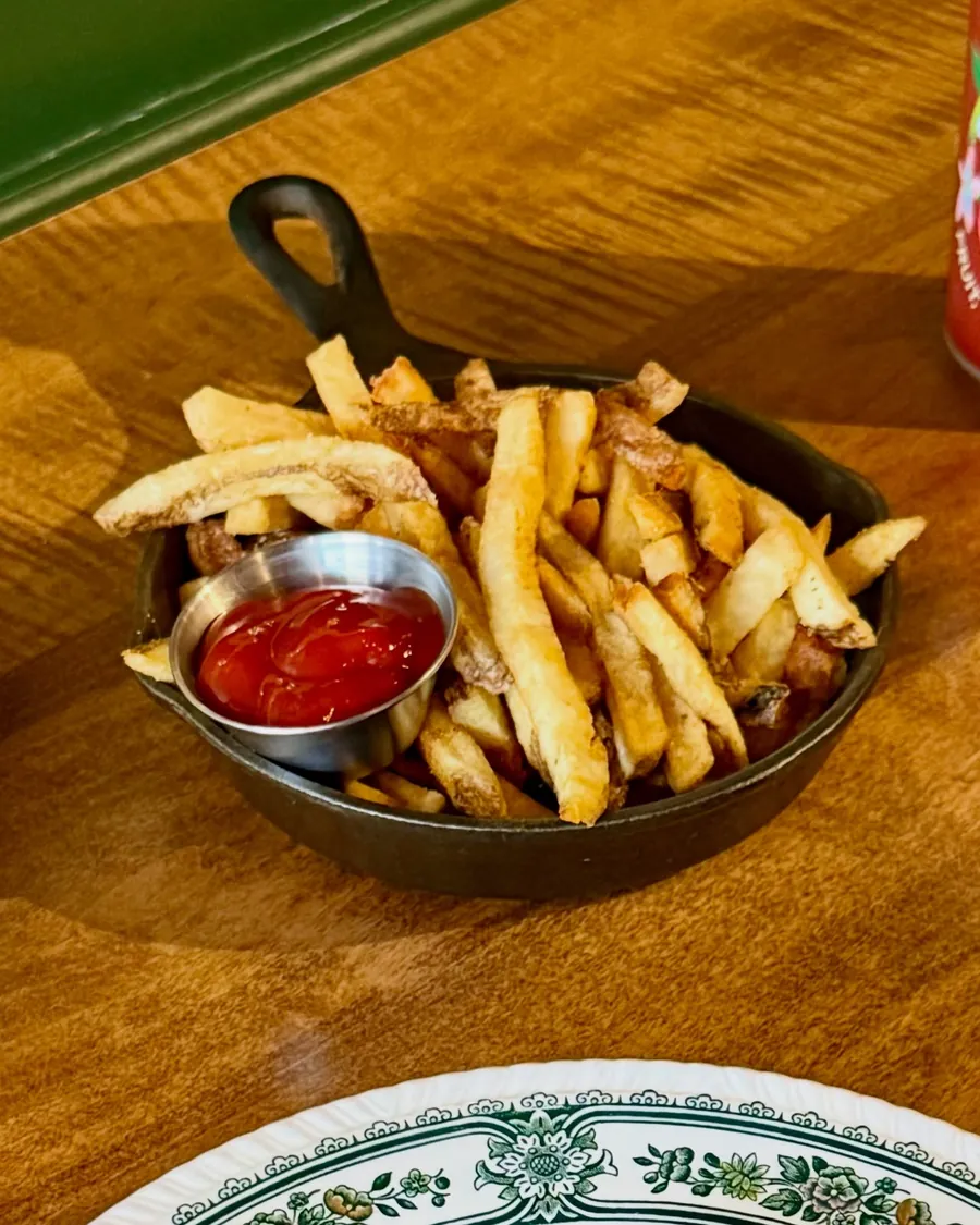 Fresh cut fries in a skillet with ketchup