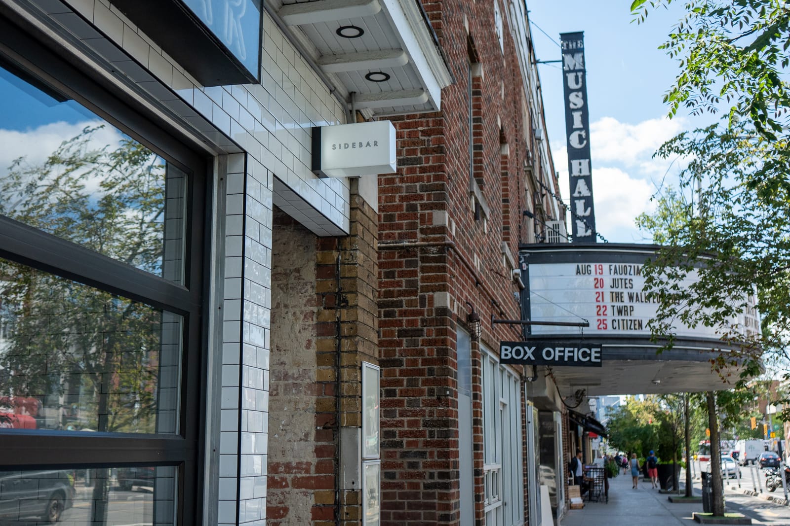 Danforth Avenue in daylight: the Sidebar front with the Danforth Music Hall box office and marquee right next door